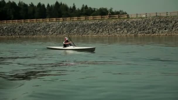 Tracking kayaker rowing on lake while getting closer — Stock Video