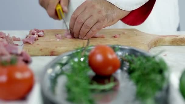 Carnicero cortando carne de pavo con plato verde delante — Vídeo de stock