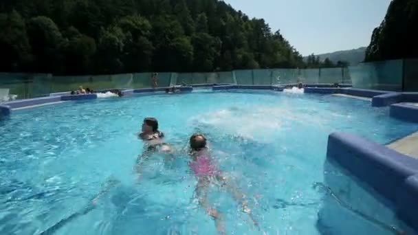 Bambini che nuotano nella piscina all'aperto vicino alla gru del fiume sparato — Video Stock