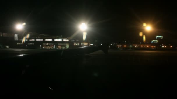 Aeropuerto por la noche desde la ventana del avión — Vídeos de Stock