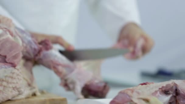Мясник отрезает кожу от мяса индейки — стоковое видео