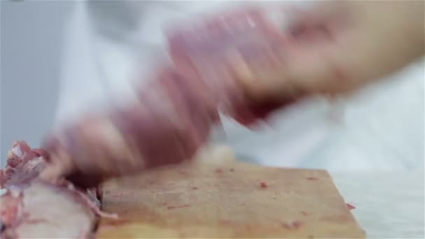 Человек на кухне режет куски мяса индейки — стоковое видео