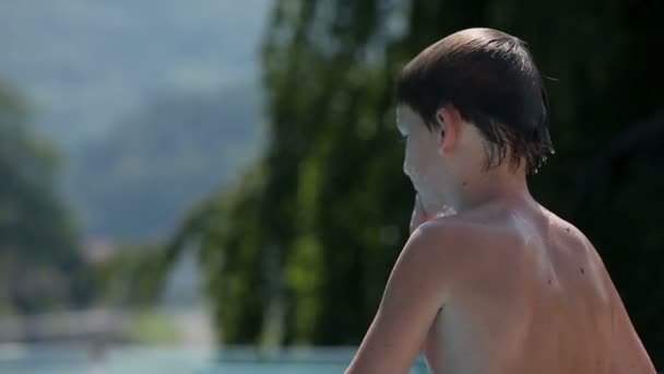 Jonge jongen voorbereiden om te springen naar zwembad water — Stockvideo