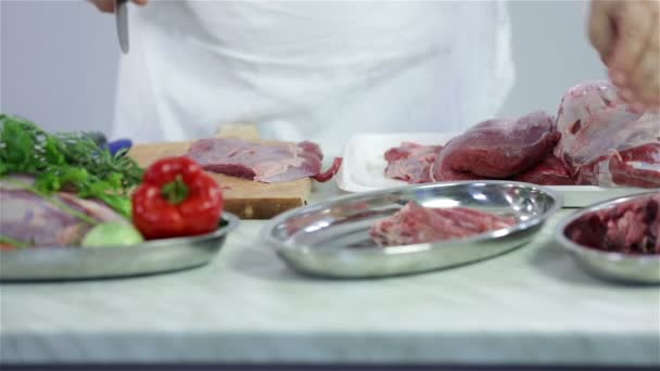 Мясник режет красное мясо на мелкие кусочки — стоковое видео