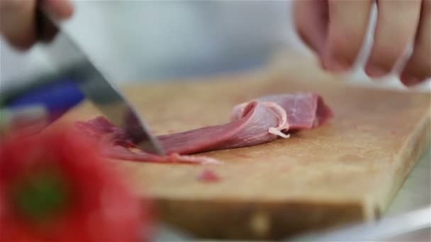 Extreme Nahaufnahme des Schneidens von rotem Fleisch auf Holzteller — Stockvideo