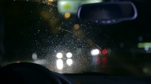 Disparo desenfocado a través del parabrisas en la noche lluviosa — Vídeos de Stock