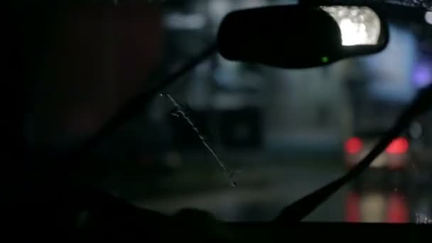 Car wipers are removing rain in unfocused shot at night — Stock Video