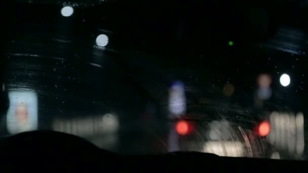 Shot through car windshield on rainy night — Stock Video