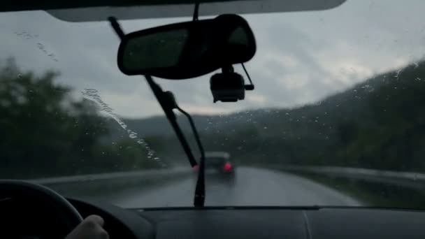 Girato attraverso il parabrezza durante la guida in autostrada la sera piovosa — Video Stock
