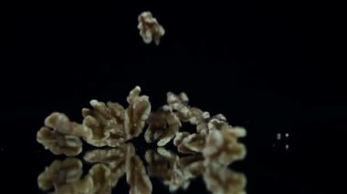 ağır çekimde siyah arka plan üzerine düşen ceviz