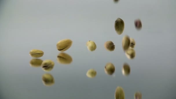 Des pistaches tombent sur le miroir au ralenti. 