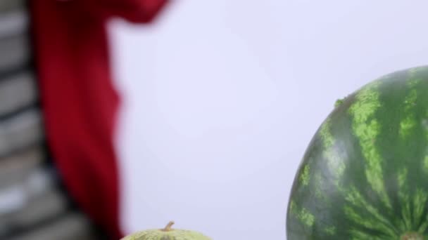 Nahaufnahme einer durchdringenden Wassermelone mit Stroh mit sichtbarem Mann im Hintergrund
