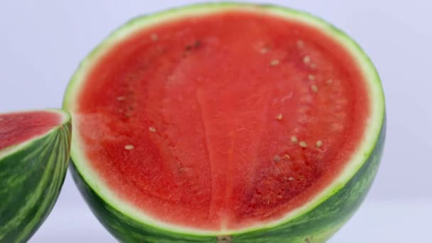 Juicy watermelon is pierced with violet straw — Stock Video