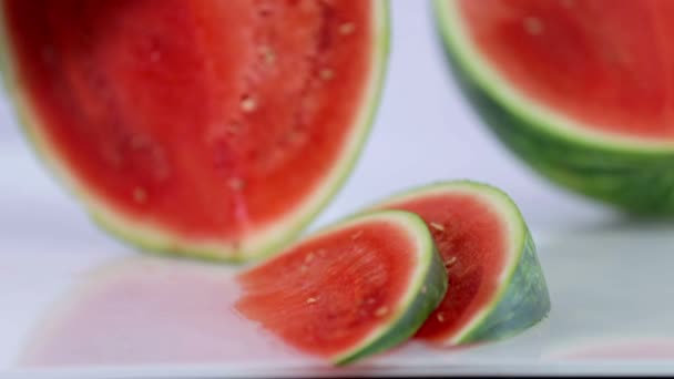 Hålla vattenmelon vertikalt och skivning det med stor kniv — Stockvideo