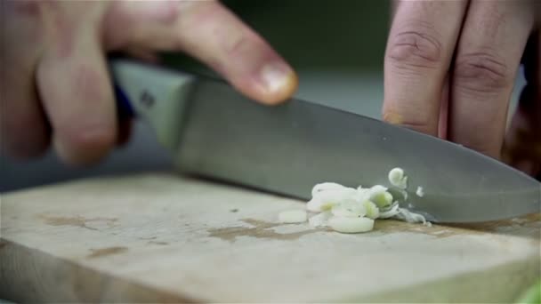 Нарезание порея на деревянном столе — стоковое видео