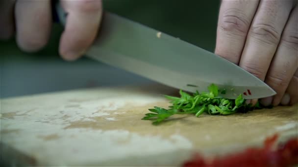 Close-up snijden van peterselie op een houten bureau — Stockvideo