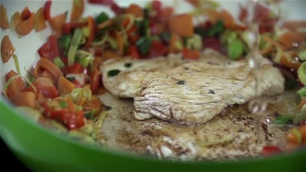 Verser de l'eau dans une casserole avec steak et légumes — Video