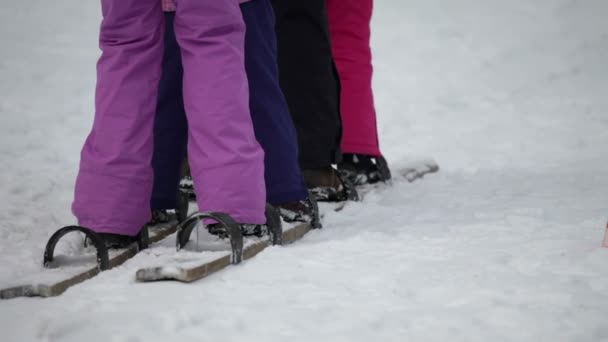 Legs of kids trying to synchronize their walking on wooden skis — Stock Video