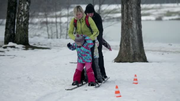 Family struggling to enjoy walking in the line on large wooden skis — Stock Video