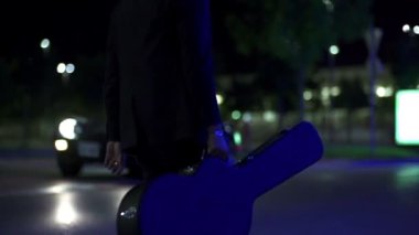 yolda yavaş mavi arabanın önünde gitarist