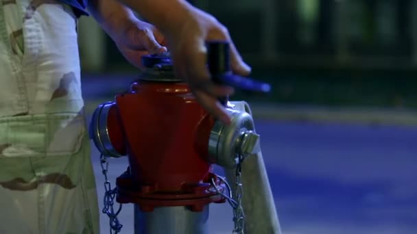 Парень ослабляет гидрант с его инструментами, чтобы использовать большое количество воды — стоковое видео