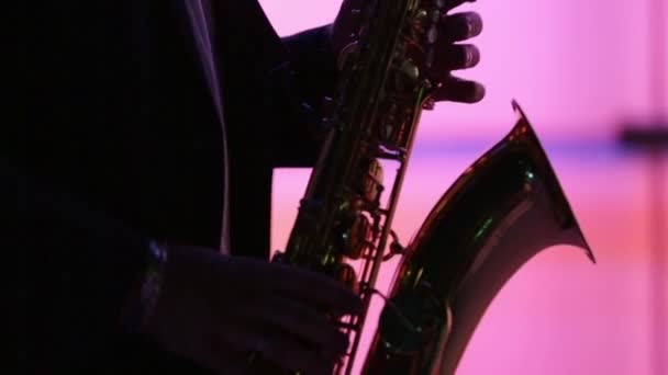 Hombre figura jugando saxofón en lwo luz — Vídeos de Stock