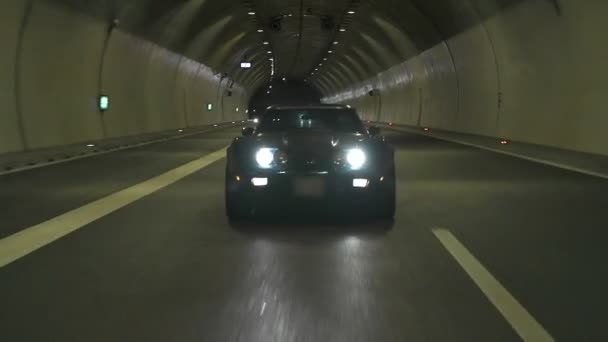 Vista diagonal del Corvette azul que conduce a través del túnel de la carretera — Vídeo de stock