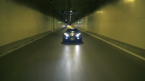 Corvette azul conduciendo por la noche en un túnel — Vídeo de stock