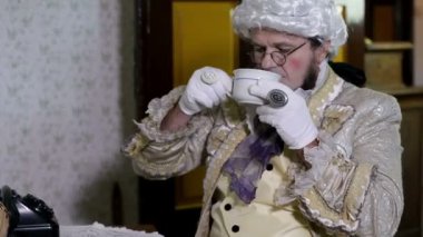 людина з білим перуку пити чай