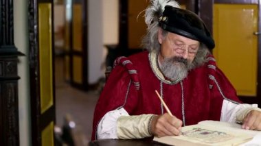 adam giyerek bir modern giyimli adamla konuşuyor