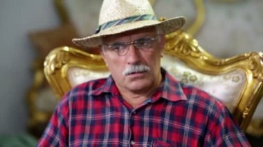 altın bir sandalyede oturan yaşlı çiftçi