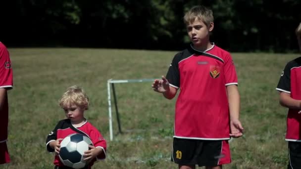 Junge Fußballer klatschen an sonnigem Tag — Stockvideo