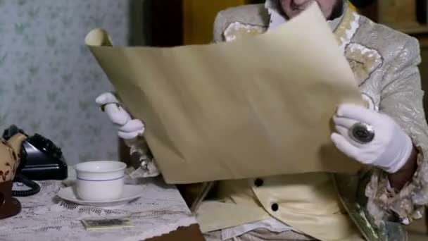 Man from enlightenment unrolling a large map — Stock Video