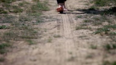 kameraya doğru toprak üzerinde yürüme yalınayak kişi