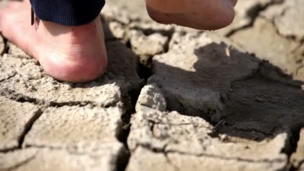 Femme pieds nus marchant sur un sol sec et fissuré — Video