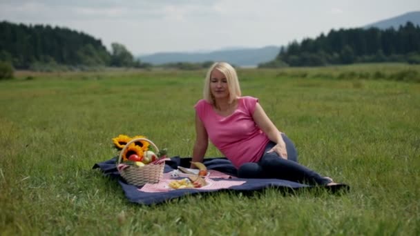 Gravid kvinna vilar under picknick — Stockvideo