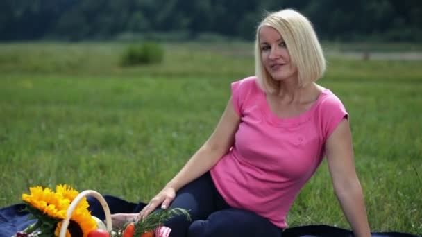 Weibchen pflücken Beeren beim Picknick in der Natur — Stockvideo