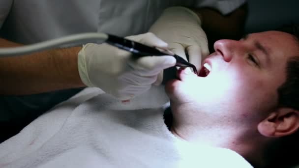 Dentist splashing clients lower teeth with water spurt — Stock Video