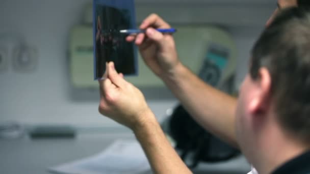 Zubař ukazující klienta jeho rentgenové — Stock video