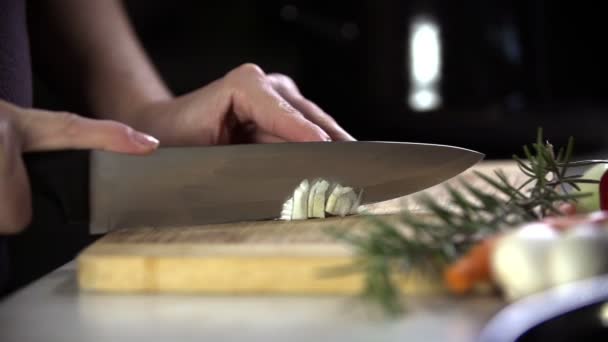 Cutting the onion into pieces on a wooden plate — Stock Video