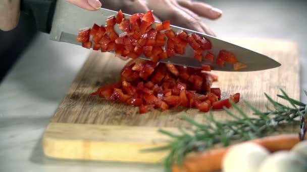 Couper le poivron rouge en petits morceaux sur un bureau — Video