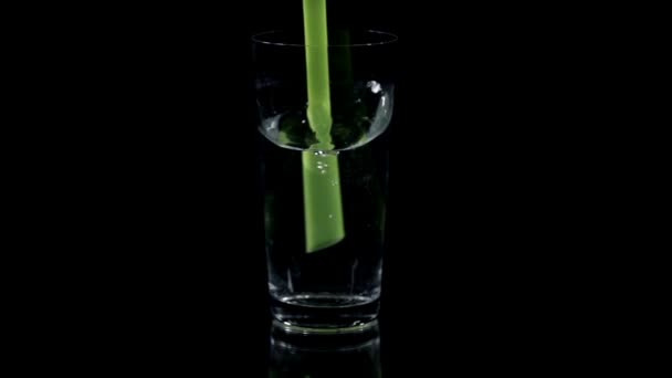 Drink with a green straw on black background — Stock Video