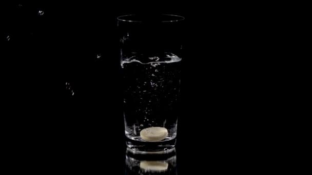 Tablet vitaminu krouží trochu na dně sklenice vody — Stock video