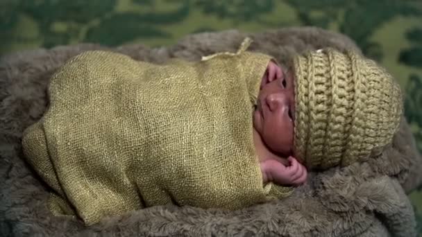 Baby lying in a sack looking like knitwear — Stock Video