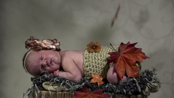 Sleeping baby with falling autumn leaves — Stock Video
