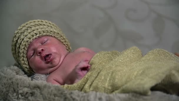 Baby täckt med bruna kläder leenden och flyttar armarna i slo-mo — Stockvideo