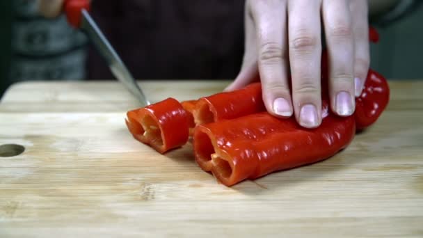 Versnijden peper met klein keukenmes op houten bureau — Stockvideo