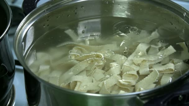 Добавление масла в макароны в воде — стоковое видео