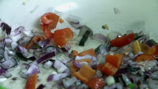 Додавання нарізаного перцю в цибулю на сковороді — стокове відео