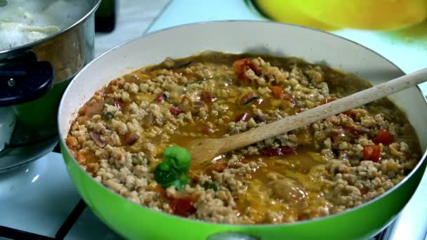 Ajouter quelques épices vertes sur le tourteau de soja bouillant dans la casserole — Video